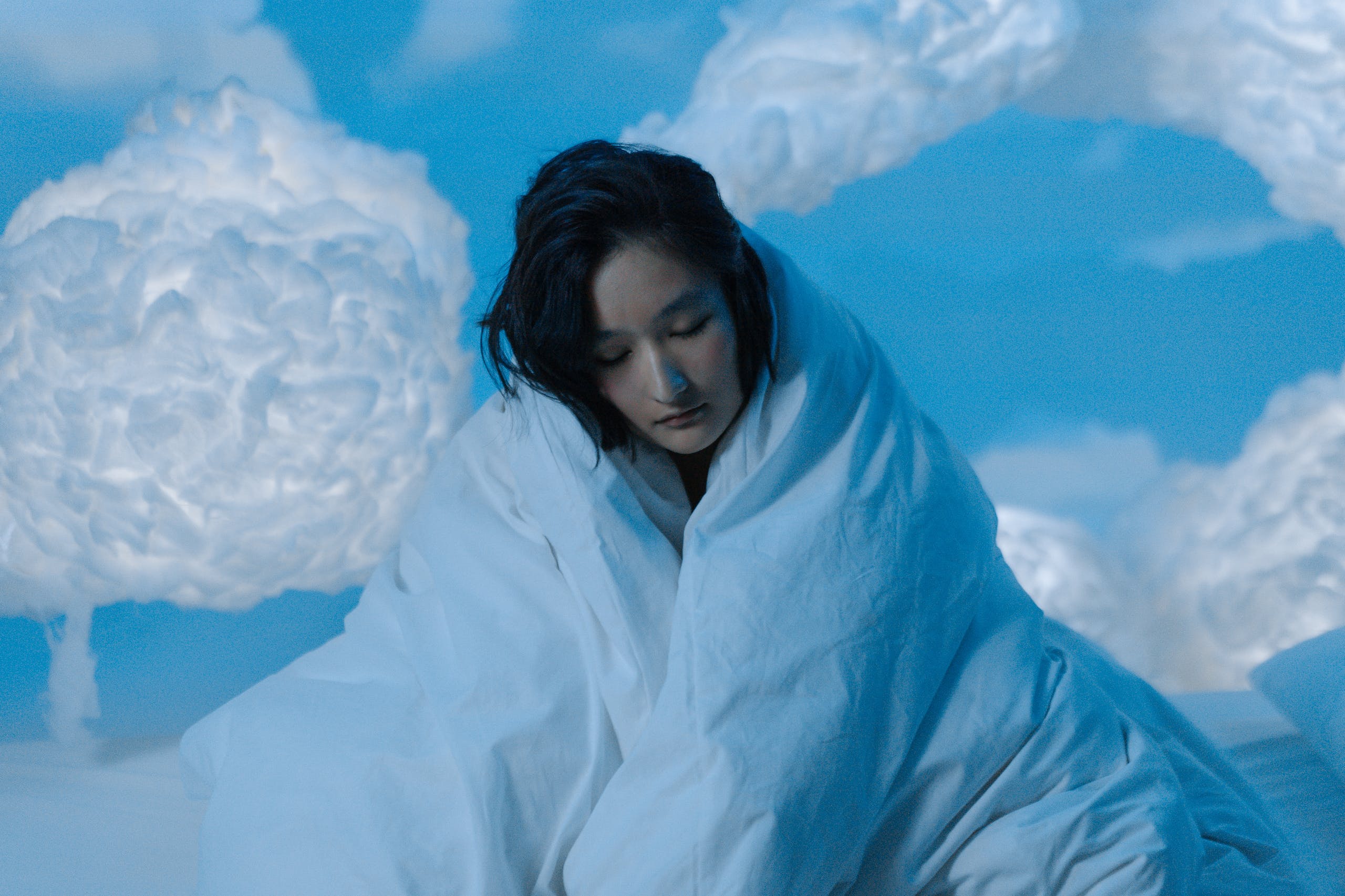 Woman in White Winter Coat Standing on Snow Covered Ground Under Blue Sky