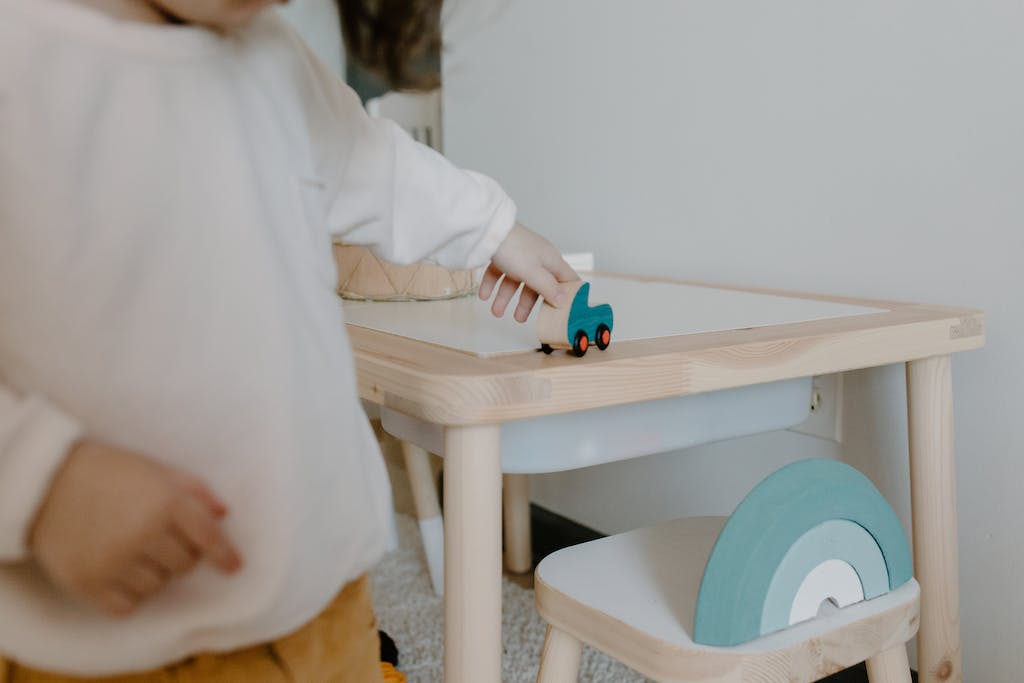 A Person in Beige Sweater Playing Wooden Toy